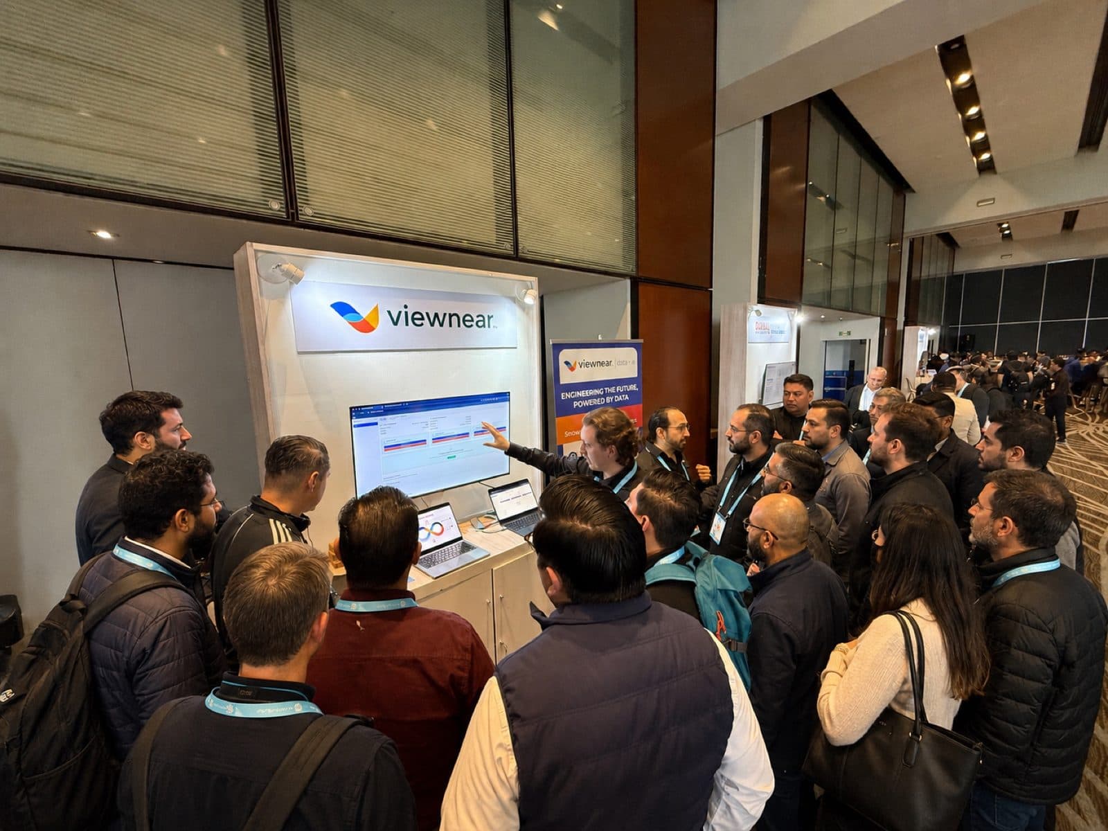 A crowd gathered around the Viewnear booth watching a live product demo